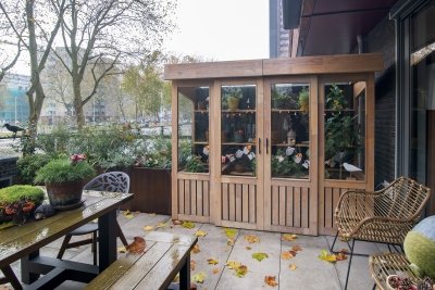 Tuinkas van robiniahout op het terras: glazen wanden, schappen voor de planten en een uitzetraam op rvs-uitzetters | maatwerk van Luc en Roel, Rotterdam